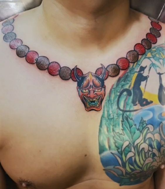 Hình xăm mặt nạ oni trên ngực, phong cách màu sắc, chi tiết cao, độ phân giải HD.