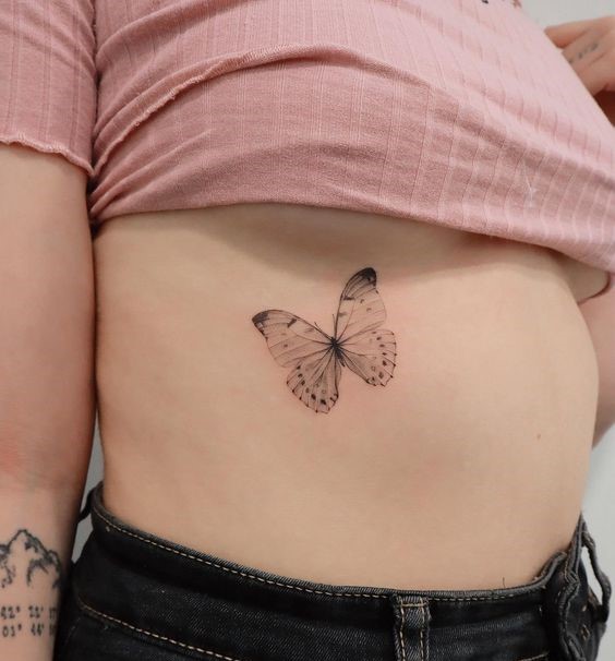 Hình xăm bướm mini ở eo, phong cách blackwork, chi tiết tinh tế, độ phân giải HD.