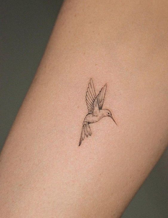 hình xăm chim mini tông trắng đen Hình xăm chim ruồi mini trên cánh tay, phong cách blackwork chi tiết, ảnh độ phân giải cao.