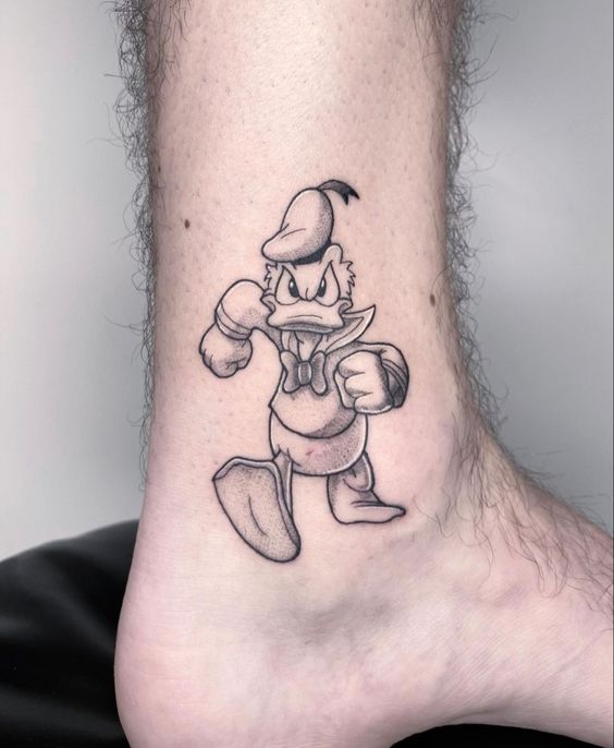 hình xăm vịt Donald mini đen trắng Hình xăm nhân vật hoạt hình trên cổ chân, phong cách blackwork, chi tiết rõ nét, ảnh HD.