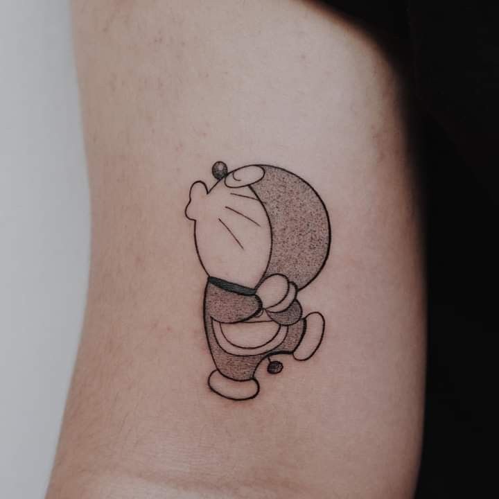 Hình xăm nhân vật hoạt hình trên tay, phong cách blackwork, chi tiết rõ nét.