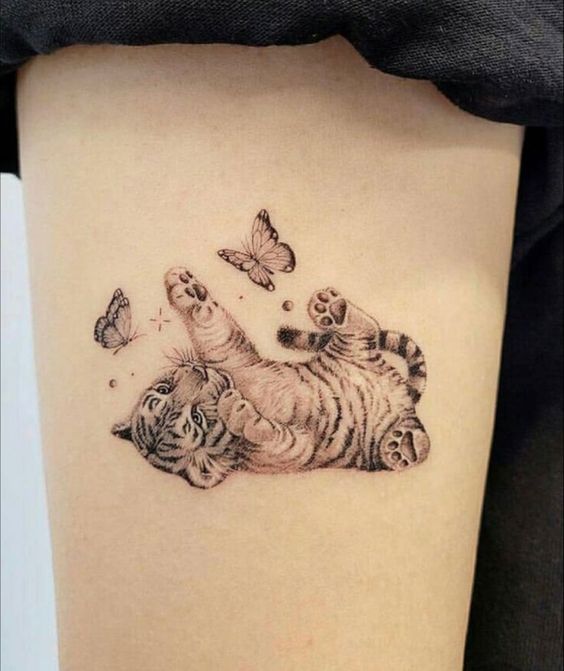 Hình xăm mini chú hổ con và bướm trên đùi, phong cách blackwork, chi tiết, độ phân giải HD.