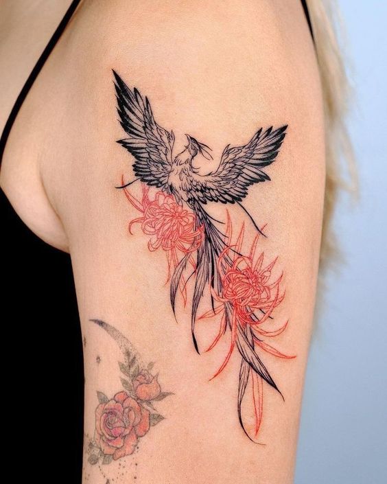 Hình xăm phượng hoàng và hoa trên bắp tay, phong cách blackwork, chi tiết rõ nét, độ phân giải HD.
