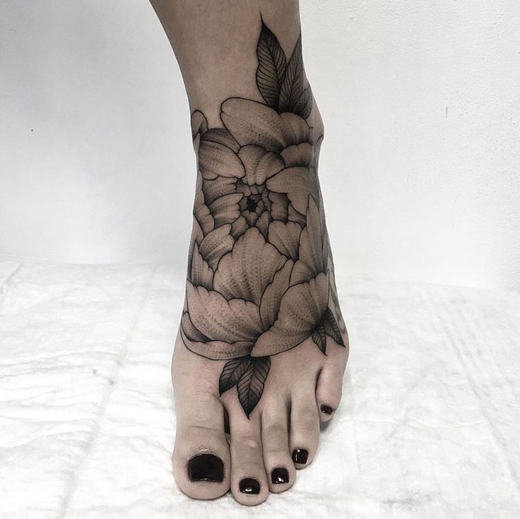 Hình xăm hoa trên bàn chân, phong cách blackwork chi tiết, ảnh chất lượng HD.