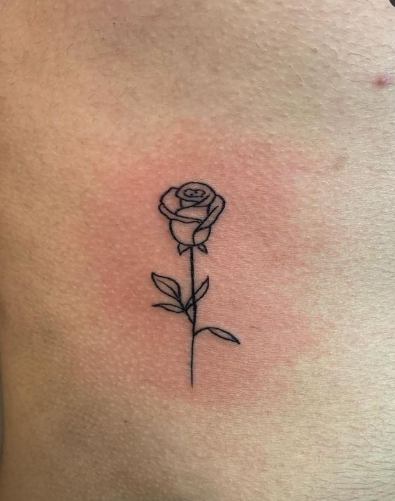 hình xăm hoa hồng đen mini gây ấn tượng sâu sắc Hình xăm hoa hồng mini phong cách blackwork trên da, vị trí sườn, độ chi tiết cao, ảnh chất lượng HD.