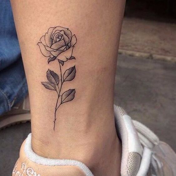 hình xăm hoa hồng mini vùng cổ chân Hình xăm hoa hồng mini trên mắt cá chân, phong cách blackwork, độ chi tiết cao, ảnh HD.