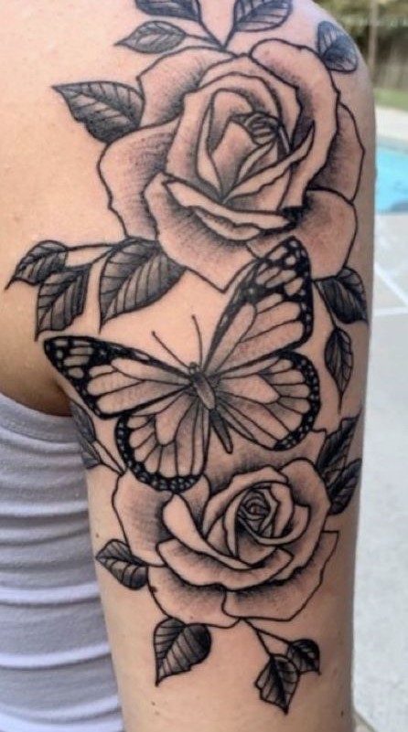 Hình xăm hoa hồng và bướm trên bắp tay, phong cách blackwork chi tiết, độ phân giải HD.