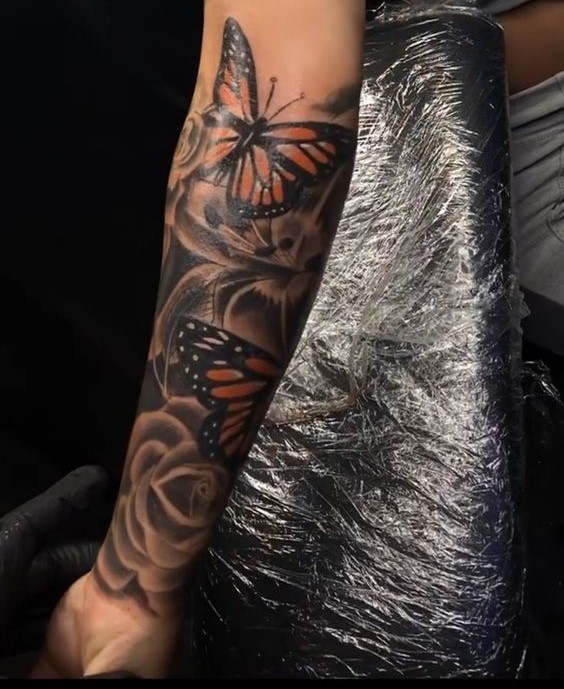 Hình xăm cánh tay bướm và hoa phong cách blackwork chi tiết, độ phân giải HD.