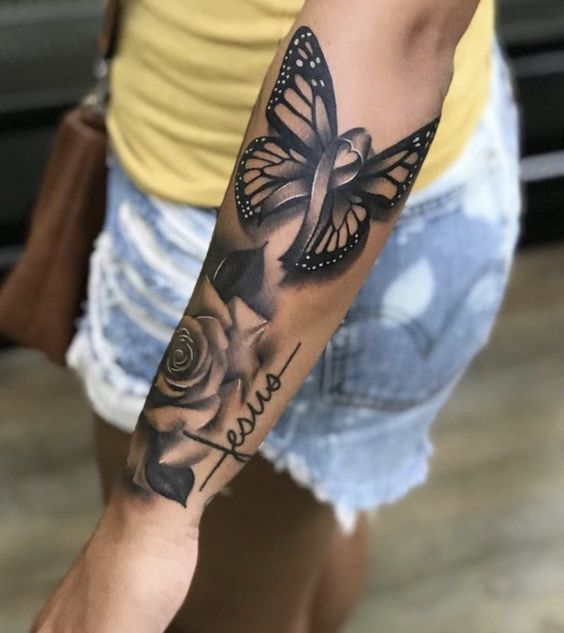 Hình xăm bướm và hoa hồng trên cánh tay, phong cách blackwork, chi tiết rõ nét, độ phân giải HD.