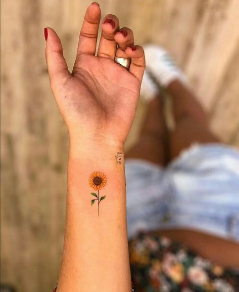 Hình xăm hoa hướng dương nhỏ gọn trên cổ tay Hình xăm hoa hướng dương mini trên cổ tay, phong cách màu sắc, chi tiết rõ nét, ảnh HD.