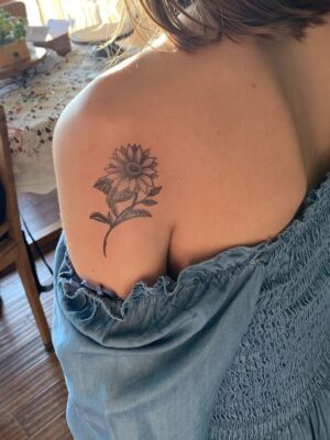 Hoa hướng dương xăm bằng mực đen trên vai Hình xăm hoa trên vai, phong cách blackwork chi tiết, ảnh HD.