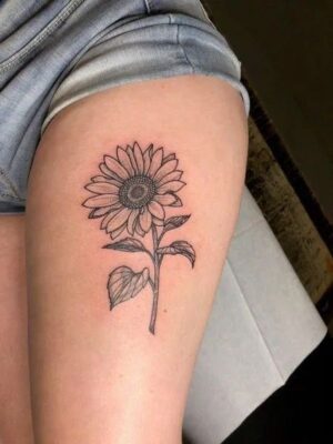 Hình xăm hoa hướng dương trên bắp đùi Hình xăm hoa hướng dương trên đùi, phong cách blackwork, chi tiết rõ nét, ảnh HD.