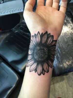 Hình xăm hoa hướng dương trên cổ tay Hình xăm hoa hướng dương trên cổ tay, phong cách blackwork chi tiết, độ phân giải HD.