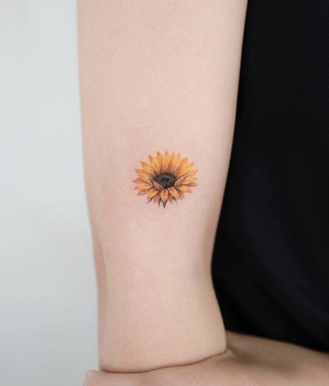 hình xăm hoa hướng dương kích thước nhỏ dễ thương Hình xăm hoa hướng dương mini trên cánh tay, phong cách màu nước, chi tiết rõ nét, độ phân giải HD.