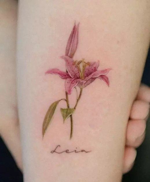 Hình xăm hoa ly mini đang trở thành một trào lưu mới Hình xăm hoa lily màu nước trên cánh tay, chi tiết tinh tế, độ phân giải HD.