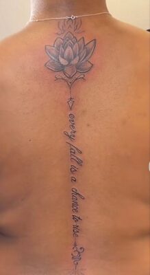 Hình xăm hoa sen và chữ trên lưng, phong cách blackwork, chi tiết rõ nét, độ phân giải HD.