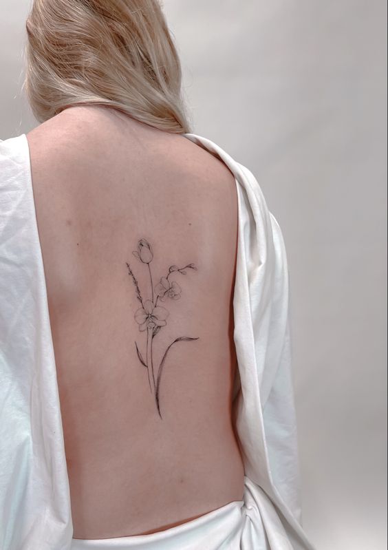 Hình xăm hoa phong cách blackwork trên lưng, chi tiết tối giản, ảnh HD.