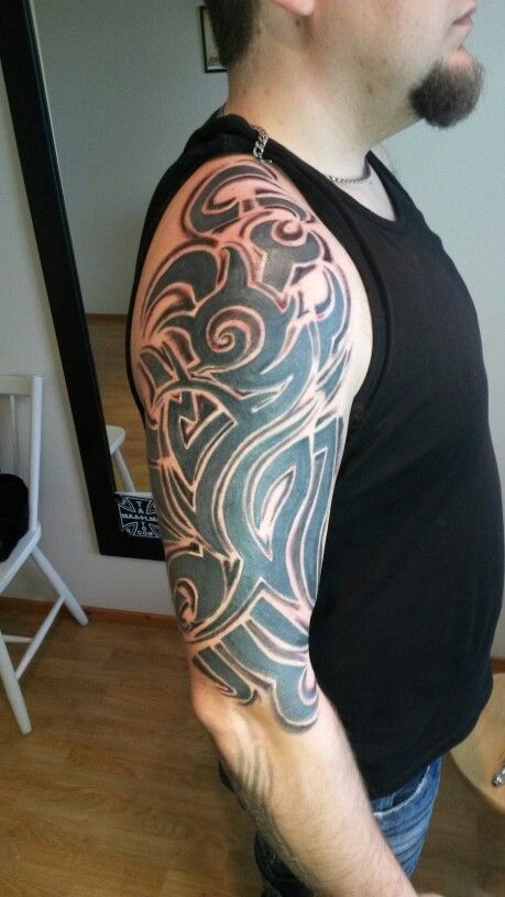 Hình xăm tribal trên cánh tay, phong cách blackwork chi tiết, chất lượng HD.