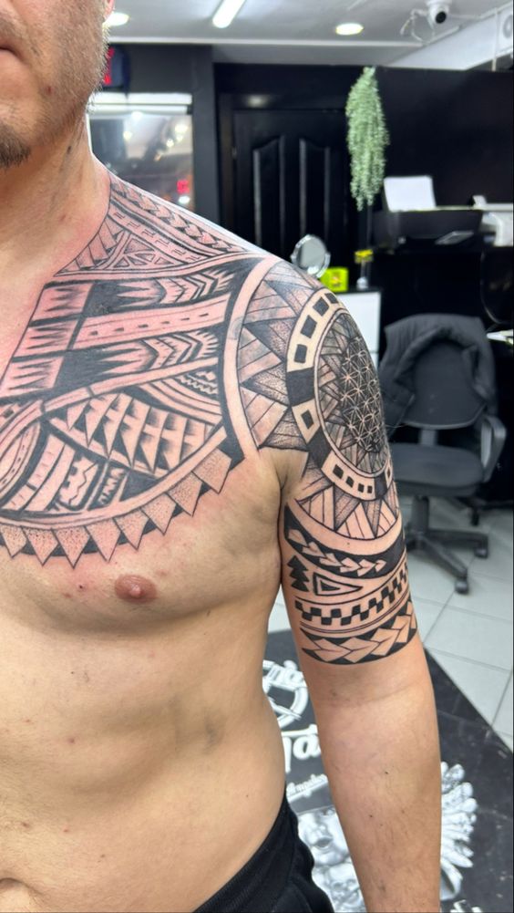 Hình xăm hoa văn bộ lạc trên vai và ngực, phong cách blackwork, chi tiết rõ nét, độ phân giải HD.