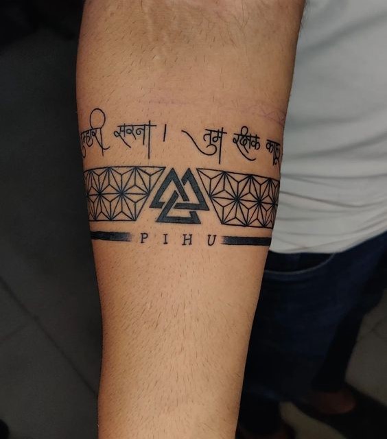 Hình xăm chữ và họa tiết hình học trên cánh tay, phong cách blackwork, chi tiết rõ nét, ảnh HD.