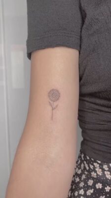 hình xăm hướng dương ở bắp tay Hình xăm hoa mini trên cánh tay, phong cách blackwork, chi tiết cao, độ phân giải HD.