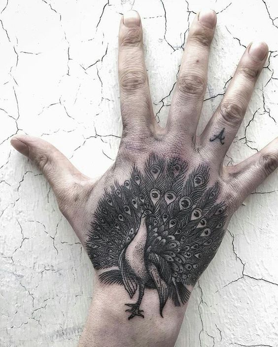 Hình xăm con công trên mu bàn tay, phong cách blackwork, chi tiết tinh xảo, ảnh độ phân giải HD.