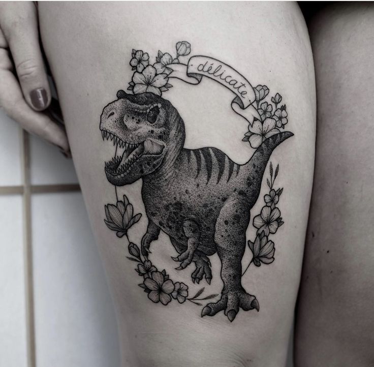 Hình xăm khủng long blackwork trên đùi, chi tiết hoa, phong cách cổ điển, ảnh độ phân giải cao.