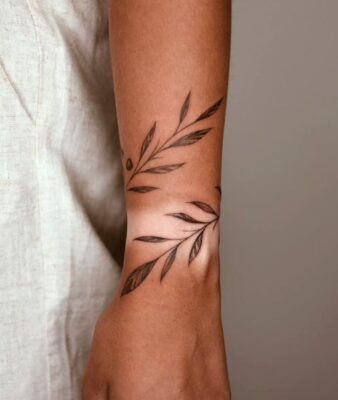 Hình xăm lá olive trên cánh tay, phong cách blackwork, chi tiết rõ nét, ảnh HD.