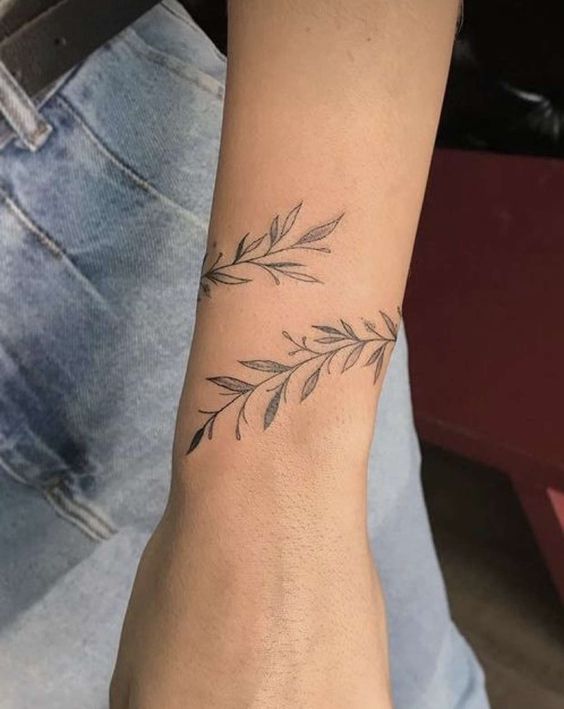Hình xăm lá cây tinh tế trên cổ tay, phong cách blackwork, chi tiết rõ nét, ảnh HD.