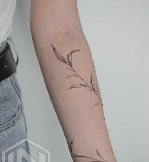 Hình xăm lá cây phong cách blackwork trên cánh tay, chi tiết tinh tế, ảnh HD.