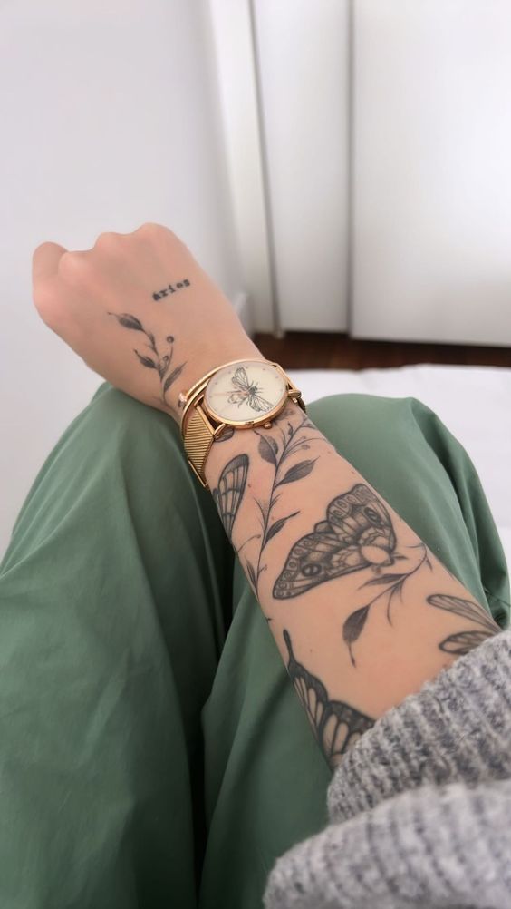 Hình xăm bướm và lá phong cách blackwork trên cánh tay, chi tiết tinh xảo, ảnh HD.