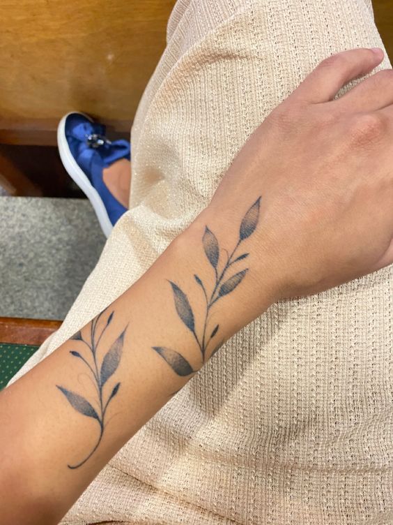 Hình xăm lá trên cổ tay, phong cách blackwork, chi tiết rõ nét, ảnh chất lượng HD.