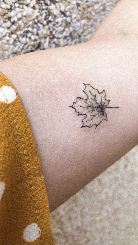 hình xăm lá phong basic trên bắp đùi Hình xăm lá phong mini trên cánh tay, phong cách blackwork, chi tiết tinh tế, độ phân giải HD.