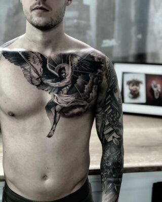Hình xăm thiên thần blackwork chi tiết trên ngực và tay, phong cách cổ điển, độ phân giải HD.