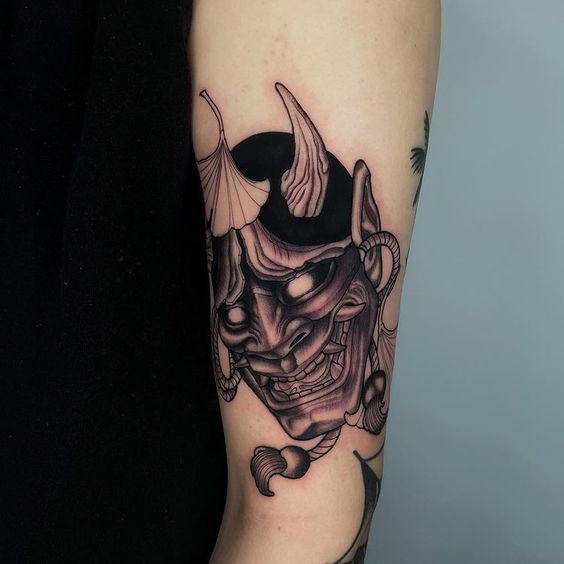 Hình xăm mặt nạ Oni phong cách blackwork trên tay, chi tiết sắc nét, độ phân giải cao.