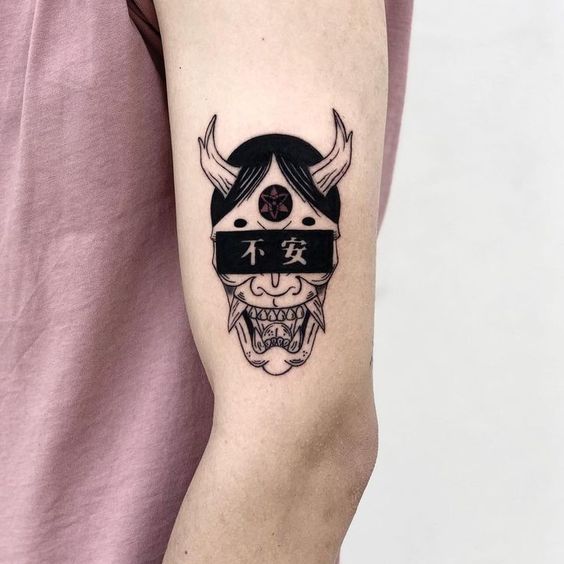Hình xăm mặt nạ Oni trên tay, phong cách blackwork, chi tiết rõ nét, độ phân giải HD.