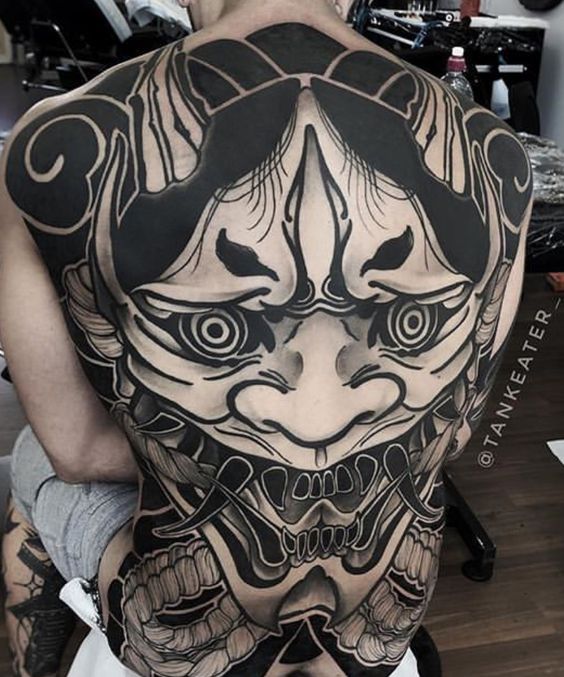 Hình xăm mặt quỷ phong cách blackwork trên lưng, chi tiết cao. Ảnh chất lượng HD.