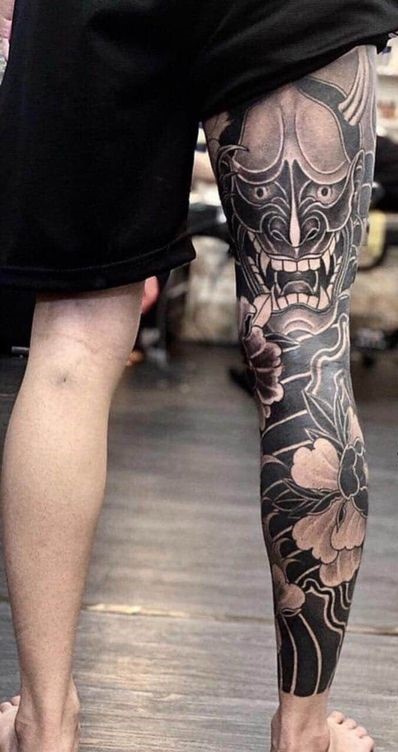 Hình xăm mặt nạ Oni và hoa, phong cách blackwork, chi tiết trên chân, ảnh HD.