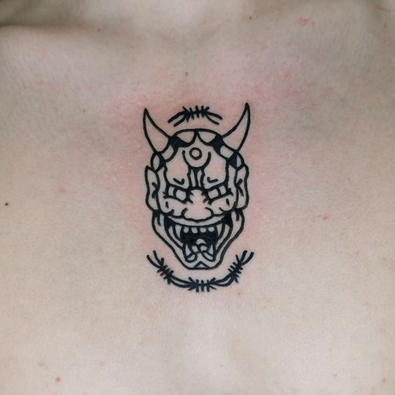 Hình xăm mặt quỷ phong cách blackwork trên ngực, chi tiết rõ nét, độ phân giải HD.