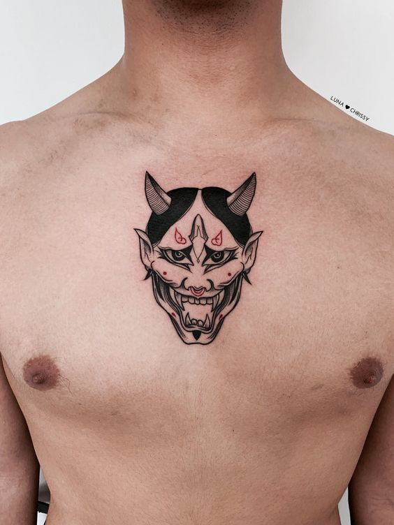 Hình xăm mặt quỷ trên ngực, phong cách blackwork, chi tiết rõ nét, ảnh chất lượng HD.