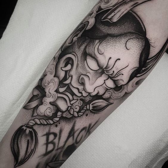 Hình xăm mặt nạ Oni trên tay, phong cách blackwork chi tiết, ảnh độ phân giải cao.