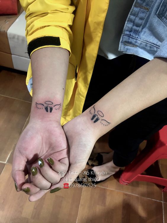 Hình xăm bàn chân thiên thần dễ thương Hình xăm mini thiên thần đôi cánh trên cổ tay, phong cách đơn giản, ảnh chất lượng HD.