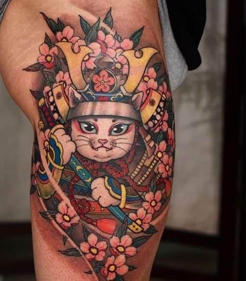 hình xăm mèo samurai kết hợp họa tiết hoa anh đào Hình xăm mèo samurai trên đùi, phong cách màu sắc, chi tiết rõ nét, độ phân giải HD.