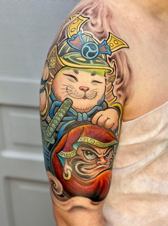 hình xăm mèo samurai và búp bê daruma Hình xăm mèo samurai màu sắc trên bắp tay, phong cách hoạt hình, độ chi tiết cao, ảnh HD.