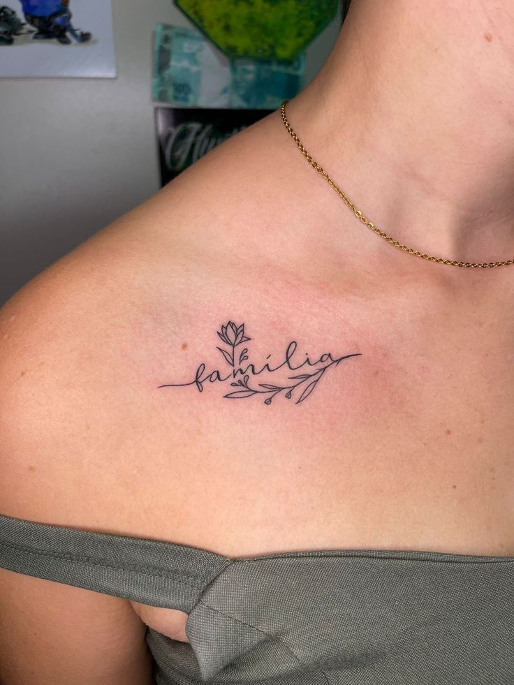 Hoa hồng và chữ 'gia đình' mini tinh tế Hình xăm chữ và hoa mini trên vai, phong cách blackwork, ảnh HD chi tiết.