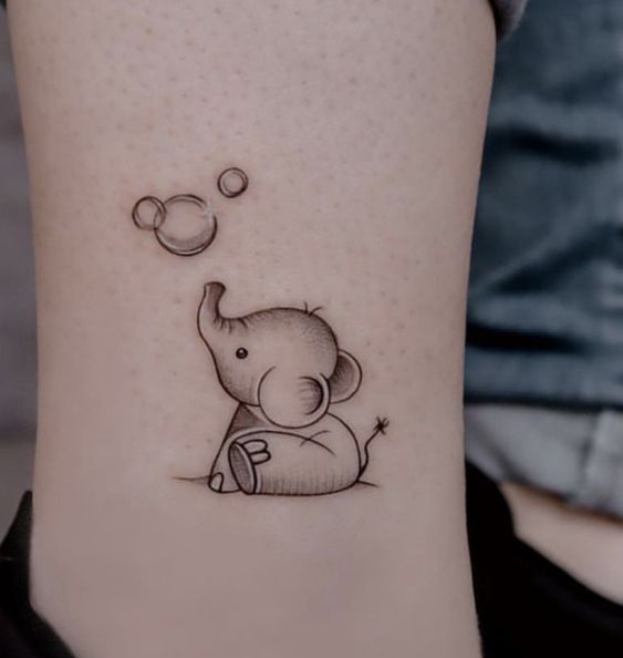 Hình xăm voi mini, phong cách blackwork, trên chân, chi tiết tinh tế, độ phân giải HD.