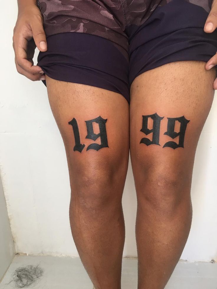 Hình xăm năm sinh ấn tượng trên hai đùi Hình xăm số 1999 trên đùi, phong cách blackwork, chi tiết rõ nét, ảnh HD.