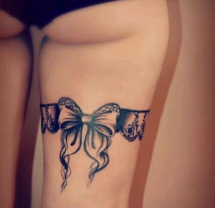 hình xăm nơ nổi bật trên đùi Hình xăm nơ ren ở đùi, phong cách blackwork, chi tiết, ảnh HD.