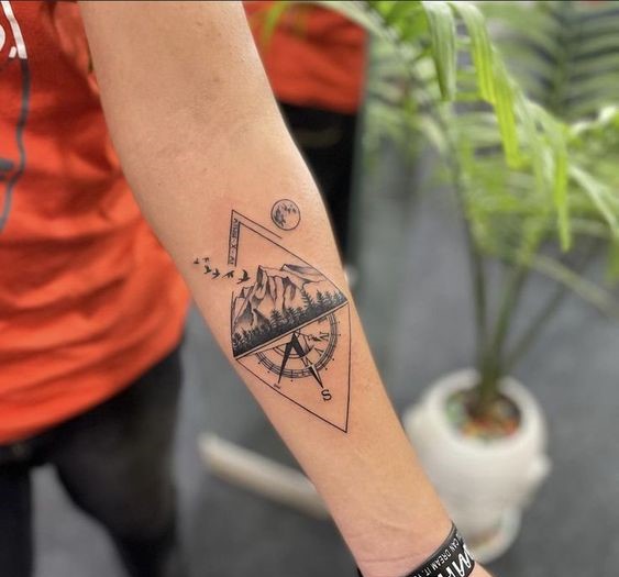 Hình xăm núi và la bàn trên cánh tay, phong cách blackwork chi tiết, độ phân giải HD.