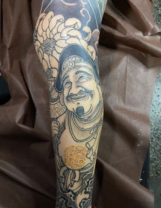 Ông Thần Tài và hoa mẫu đơn kín tay Hình xăm thần tài phong cách blackwork trên cánh tay, chi tiết cao, độ phân giải HD.